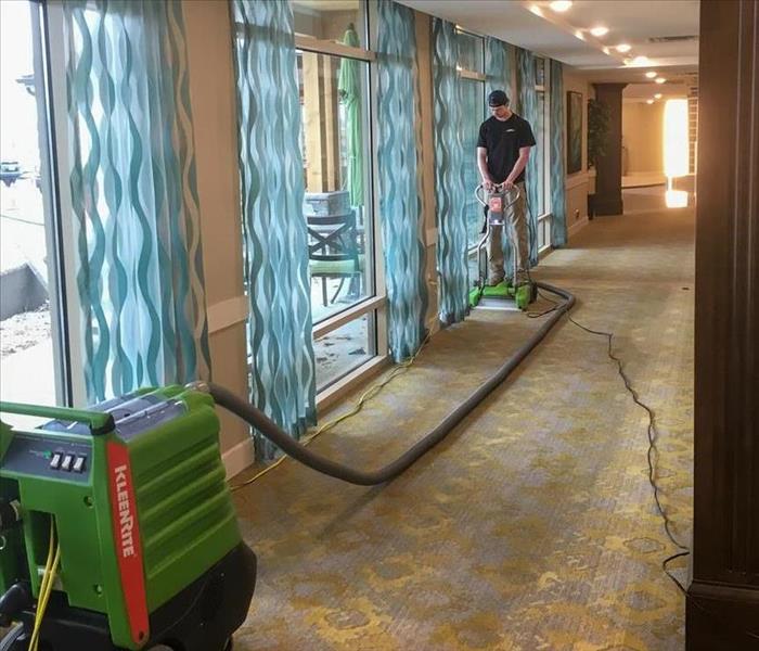 SERVPRO technician extracting water from the carpet