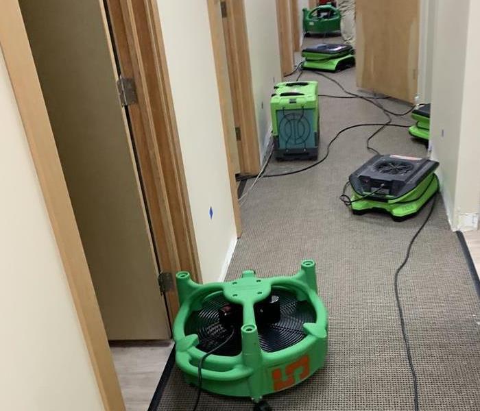 Water damage on the floor of an office hallway