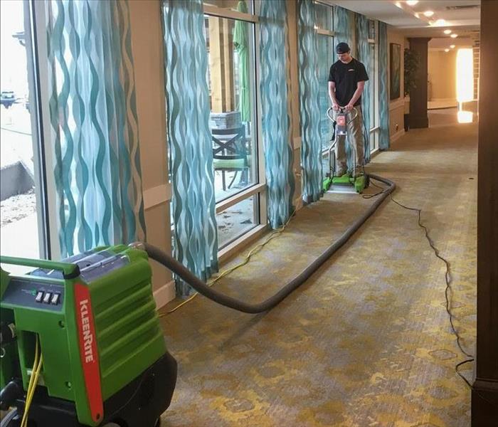 SERVPRO tech extracting water from a carpet in a hotel