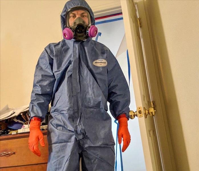 SERVPRO tech in PPE cleaning a home