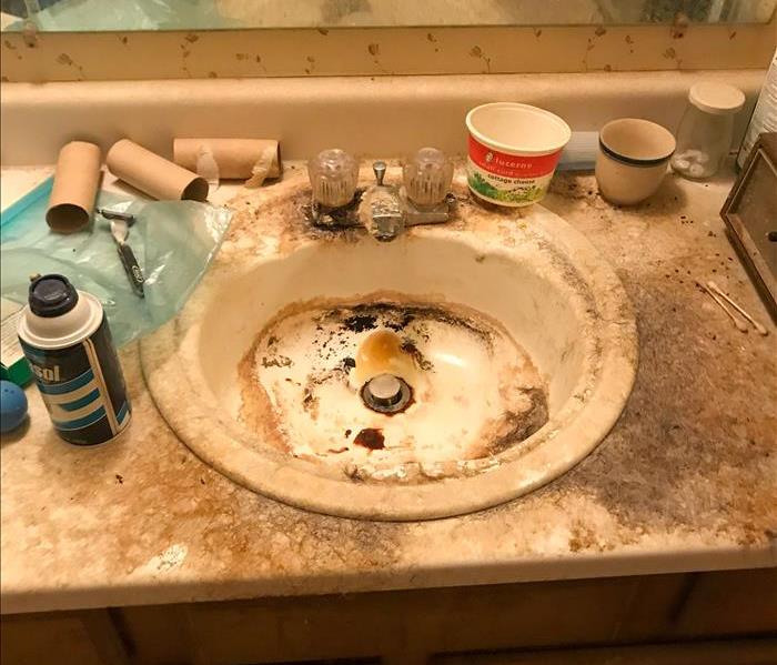 Bathroom counter covered in dirt and mold